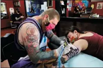  ?? GARY CORONADO/LOS ANGELES TIMES ?? Andrew Wagner of Olivehurst applies an octopus design to the arm of Jordan Curiel of Marysville at Heart & Soul Tattoo on Wednesday in Yuba City. Every 30 minutes, Wagner must stop and sanitize the table.