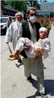  ??  ?? INNOCENT VICTIMS: A man carries an injured boy to a hospital after a blast during a funeral ceremony in Jalalabad, and an Afghan soldier carries a newborn baby at the site of an attack in Kabul on Tuesday. — AFP