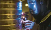  ?? COURANT FILE PHOTO ?? A welder tack-welds a part for a B-52 at the Columbia Manufactur­ing plant in Columbia.