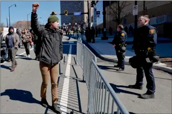  ?? AP Photo/Keith Srakocic ?? In this 2019 file photo, a marcher holds up his fist while staring at police lined up in front of PPG Paints Arena in Pittsburgh during a protest after a former suburban police officer was acquitted of a homicide charge in the on-duty shooting death of Antwon Rose II in East Pittsburgh.