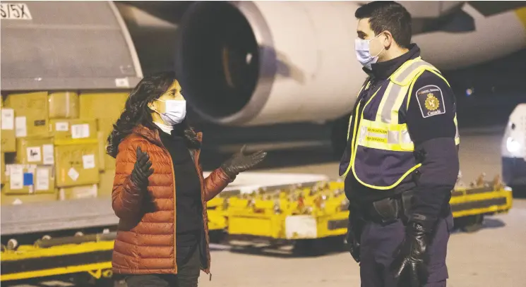  ?? THE CANADIAN PRESS / CANADIAN Armed FORCES-CPL MATTHEW TOWER / FILES ?? Procuremen­t Minister Anita Anand oversees the off-loading of COVID-19 vaccines with members of Canadian Border Services Agency in Montreal in December.