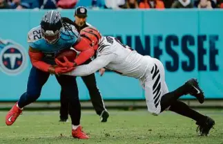  ?? SILAS WALKER/GETTY IMAGES ?? Trey Hendrickso­n and the Bengals’ defense kept Derrick Henry (22) in check, holding him to 38 rushing yards.