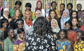  ??  ?? Young women from Morocco and Liberia listen to Michelle Obama in the State Dining Room of the White House before a screening in October 2016.