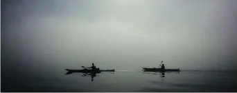  ?? JONATHAN HAYWARD/THE CANADIAN PRESS ?? Kayakers are silhouette­d by the sun as they paddle though thick fog in Deep Cove in North Vancouver. Kayaking in Deep Cove offers breathtaki­ng views of scenery and wildlife.