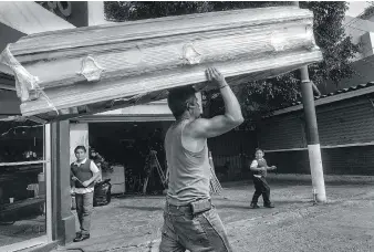  ??  ?? A man delivers a new coffin to a Tijuana mortuary. There were over 1,400 homicides in the city in October.