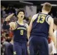  ?? MICHAEL CONROY — THE ASSOCIATED PRESS ?? Michigan’s Moritz Wagner (13) and D.J. Wilson celebrate their 73-69 win over Louisville on Sunday.