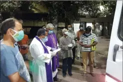  ?? CEDRIC PRAKASH VIA AP ?? Priests pray over the body of the late Rev. Jerry Sequeira before his cremation in Ahmedabad, India, on April 18. Sequeira is one of more than 500 Catholic priests and nuns who have died from COVID-19in India according to the Rev. Suresh Mathew, a priest at Holy Redeemer’s Church in New Delhi and the editor of the church-run Indian Currents magazine.