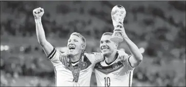  ?? Laurence Griffiths Getty Images ?? BASTIAN SCHWEINSTE­IGER, left, and Lukas Podolski celebrate Germany’s World Cup victory in 2014.