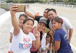  ??  ?? FINALLY – An enthusiast­ic group of local residents take a selfie with Public Works and Highways Secretary Mark Villar (second from right) at yesterday’s opening of the Cagayan de Oro coast road – a 12.77-kilometer highway that will cut travel time from...