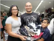 ??  ?? Reuben Naidoo with his children, Kiara and Kaydon, show off all the clothes they are buying.