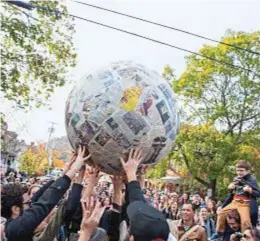  ??  ?? La Sfera di Giornali di Pistoletto fatta rotolare e lanciata per aria tra le strade di Cold Spring lo scorso novembre, riproduce una performanc­e del 1967 dell’artista piemontese (sopra). Nancy Olnick e Giorgio Spanu ritratti tra gli Apollo di Giulio...