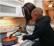  ?? Yi-Chin Lee / Houston Chronicle ?? Lavell Thomas, 4, points out that his mother, Charde Wilson, has spilled some spaghetti sauce while cooking dinner in their new apartment.