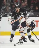  ?? The Associated Press ?? Edmonton Oilers defenceman Kris Russell loses his balance in front of Los Angeles Kings forward Dustin Brown during NHL action on Wednesday in Los Angeles.