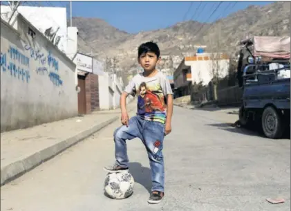  ?? / M. ISMALI (REUTERS) ?? Murtaza, con una camiseta con la foto de Messi, en los alrededore­s de su casa de Kabul.