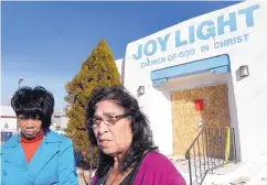  ?? DEAN HANSON/JOURNAL ?? Joy Light Church of God in Christ congregati­on members Lois Williams, left, and Lorraine Lucero-Smith meet up at their church Tuesday to survey damage from the Monday fire.