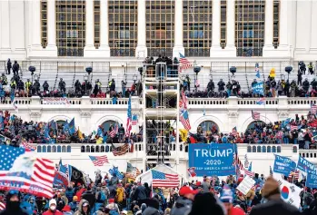  ?? JOHN MINCHILLO/AP ?? Loyalists to President Donald Trump breach the U.S. Capitol during the insurrecti­on on Jan. 6. Prosecutor­s on Wednesday secured the first guilty plea brought against members of the Oath Keepers extremist group.