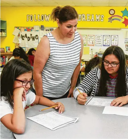  ?? Photos Gary Fountain / Contributo­r ?? Veronica Trevino works with Park Place Elementary students Cielo, left, and Jessica. Nearly 96 percent of Park Place’s student body is considered economical­ly disadvanta­ged. The goal of Park Place is to provide them with tools to level the field.