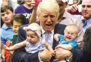  ?? THE ASSOCIATED PRESS ?? Republican presidenti­al candidate Donald Trump holds baby cousins Evelyn Kate Keane, 6 months old, and Kellen Campbell, 3 months old, following his speech Friday in Colorado Springs, Colo.