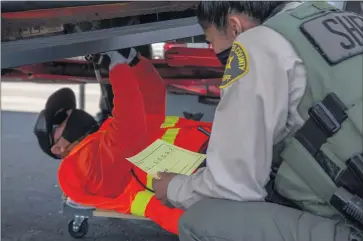  ?? PHOTOS BY CHUCK BENNETT ?? The Los Angeles County Sheriff’s Department holds an event in February at the Carson station for residents to get their vehicles’ VIN numbers etched onto their catalytic converters, making them easier to track down if the devices are stolen.