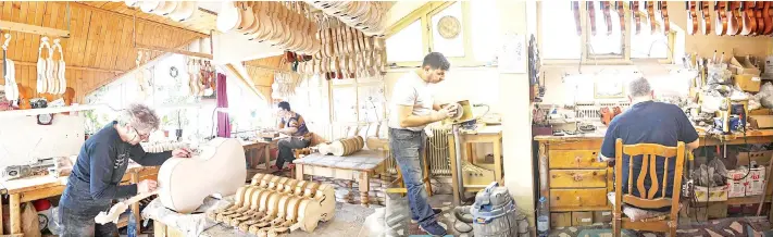  ??  ?? Combinatio­n picture of workers working on cellos at ‘Gliga’ musical instrument­s factory in Reghin city.