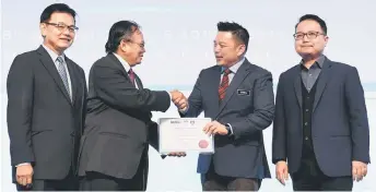  ?? — Bernama photo ?? Leiking (second right) together with Madani (right) and MARii chairman Datuk Phang Ah Tong (left) presents a token of appreciati­on to UiTM deputy vice chancellor of industry, community and alumni Professor Datuk Dr Rahmat Mohamad (second left) yesterday.