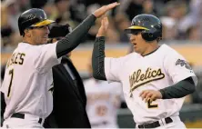  ?? Jeff Chiu / Associated Press 2010 ?? Cliff Pennington (right), celebratin­g with Adam Rosales after both scored on a double in 2010, has returned to Oakland.