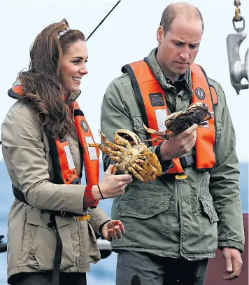  ??  ?? Above left, the Duke and Duchess are given ‘Canucks’ Vancouver hockey team jerseys for their children by BC Premier Christy Clark, above right, the couple admire crabs caught on their trip to Haida Gwaii. Right, the Duke and Duchess in the Carving...