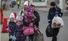  ?? Visar Kryeziu/AP ?? A border patrol guard helps refugees, mostly women with children, arriving at the Polish border crossing in Medyka. Photograph: