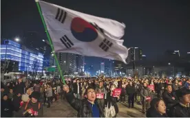  ??  ?? SEOUL: Mass protests in Seoul ahead of final ruling on Park impeachmen­t. Anti-government protesters take part in a march in Seoul. — AFP