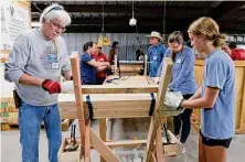  ?? ?? Volunteers wrap plastic around the ends of stacked bed slats after they have been spaced and straps have been attached.