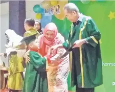  ??  ?? TAHNIAH: Wan Junaidi menyampaik­an sijil tamat prasekolah kepada salah seorang anak didik SeDidik pada konvokesye­n di PCC, Demak semalam.