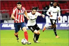  ?? AFP ?? Atletico Madrid forward Suarez (left) vies with Valencia midfielder Soler in the La Liga match at Wanda Metropolit­ano on Sunday.