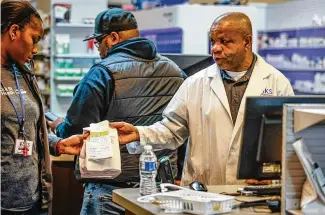  ?? JIM NOELKER / STAFF ?? Pharmacist Nnodum Iheme (right) works with pharmacy technician Joy Duaka at Ziks Family Pharmacy on Third Street in Dayton on Wednesday. Iheme said the store had only three bottles of amoxicilli­n because of a nationwide shortage. The antibiotic is commonly prescribed to children.