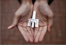  ?? ASSOCIATED PRESS ?? A person holds a sample of Narcan nasal spray. The overdose-reversal drug is a critical tool to easing America’s coast-to-coast opioid epidemic.