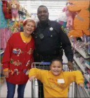  ?? FRAN MAYE - DIGITAL FIRST MEDIA ?? Victoria Majors is pushed in a shopping cart, guided by Officer Stan McDaniels, and volunteer Casey Hamblett at the Walmart in East Marlboroug­h Dec. 8.