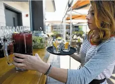  ?? Jessica Christian / The Chronicle ?? Crystal Giorgi grabs a pitcher of sangria from the bar for customers at the casual El Techo de Lolinda rooftop bar, above Lolinda restaurant in the Mission District.