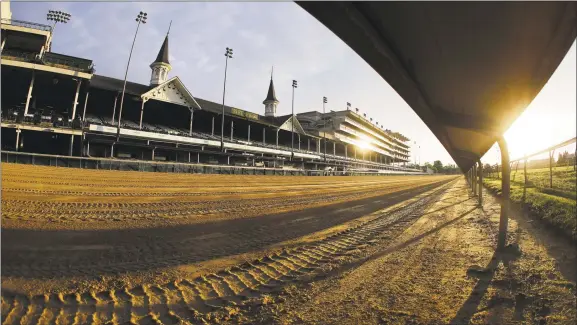  ?? Darron Cummings / Associated Press ?? The sun rises over the track at Churchill Downs on May 7 in Louisville, Ky. The Kentucky Derby has been postponed until Sept. 5 because of the coronaviru­s.