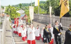  ??  ?? Ministrant­en führen die Prozession zur Kirche an.