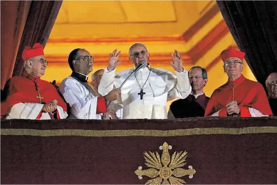  ??  ?? Francisco à varanda de São Pedro contrasta com os cardeais e com quem o antecedeu: despojado, de branco, anuncia-se bispo de Roma