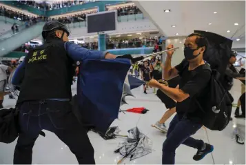  ?? Associated Press ?? ■ A policeman scuffles with a protester Sunday inside a mall in Sha Tin District in Hong Kong. Police in Hong Kong have fought with protesters as they broke up a demonstrat­ion by thousands of people demanding the resignatio­n of the Chinese territory's chief executive and an investigat­ion into complains of police violence.