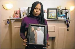  ?? Jason Armond Los Angeles Times ?? YATOYA TOY holds a photo of her brother, Anthony Lowe, a double amputee who was killed by police in Huntington Park while holding a long-bladed knife.