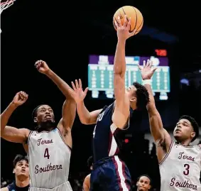  ?? Dylan Buell/Getty Images ?? Grant Singleton of Fairleigh Dickinson slices through Texas Southern’s Chris Craig (4) and PJ Henry on Wednesday night.