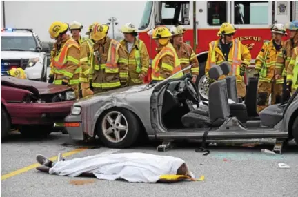  ?? MARIAN DENNIS — DIGITAL FIRST MEDIA ?? Area fire companies, law enforcemen­t and EMS assisted students Thursday with a mock crash at Owen J. Roberts High School. The scene was meant to remind students of the dangers of drinking and driving as well as distracted driving.