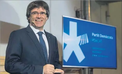  ?? QUIQUE GARCÍA / EFE ?? El presidente de la Generalita­t, Carles Puigdemont, junto al nuevo logotipo de su partido, el PDECat