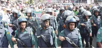  ?? — AFP ?? Bangladesh­i police stand guard as activists from Islamic organisati­ons march towards the Myanmar embassy in Dhaka on Tuesday to protest against the persecutio­n of Rohingya Muslims in Myanmar.