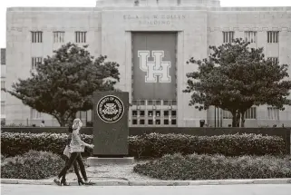  ?? Jon Shapley / Staff photograph­er ?? Two people walk near the Ezekiel Cullen Building at the University of Houston main campus on Sunday. Standardiz­ed test scores will temporaril­y be optional for admission.