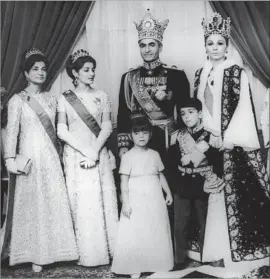  ?? Keystone-France Gamma-Keystone via Getty Images ?? THE SHAH, Mohammad Reza Pahlavi, is surrounded by his family members including his wife, Farah, pictured at his left. He was ousted from Iran in 1979 and died 19 months later after a long series of illnesses and medical mishaps.