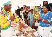  ?? ?? First Lady Dr Auxillia Mnangagwa looks at one of the fruit cocktails packaged by one of the male contestant Mr Terrence Kamutepfa during Amai’s traditiona­l cookout competitio­n finals in Mashonalan­d West province yesterday