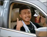  ?? RECORDER PHOTO BY ALEXIS ESPINOZA ?? Anthony Chhean shows off his Cougars coffee mug filled with goodies during the Citrus High School drive-thru graduation ceremony on Friday night.