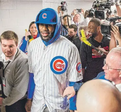  ?? | SANTIAGOCO­VARRUBIAS/ SUN- TIMES ?? LeBron James arrives wearing a full Cubs uniform to pay off hisWorld Series bet with buddyDwyan­eWade.